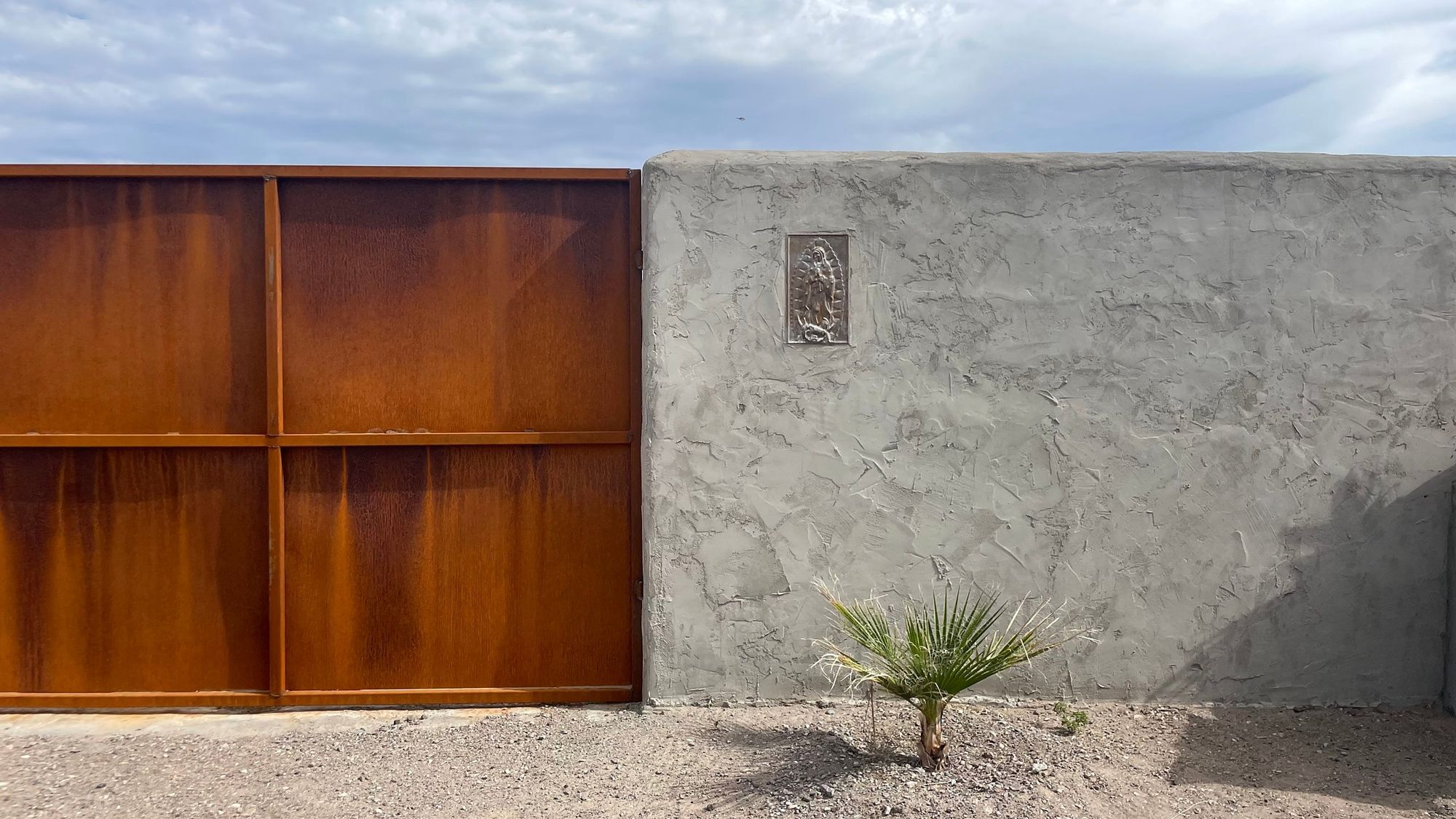 The rusted gate and plaster wall of Las Sombras