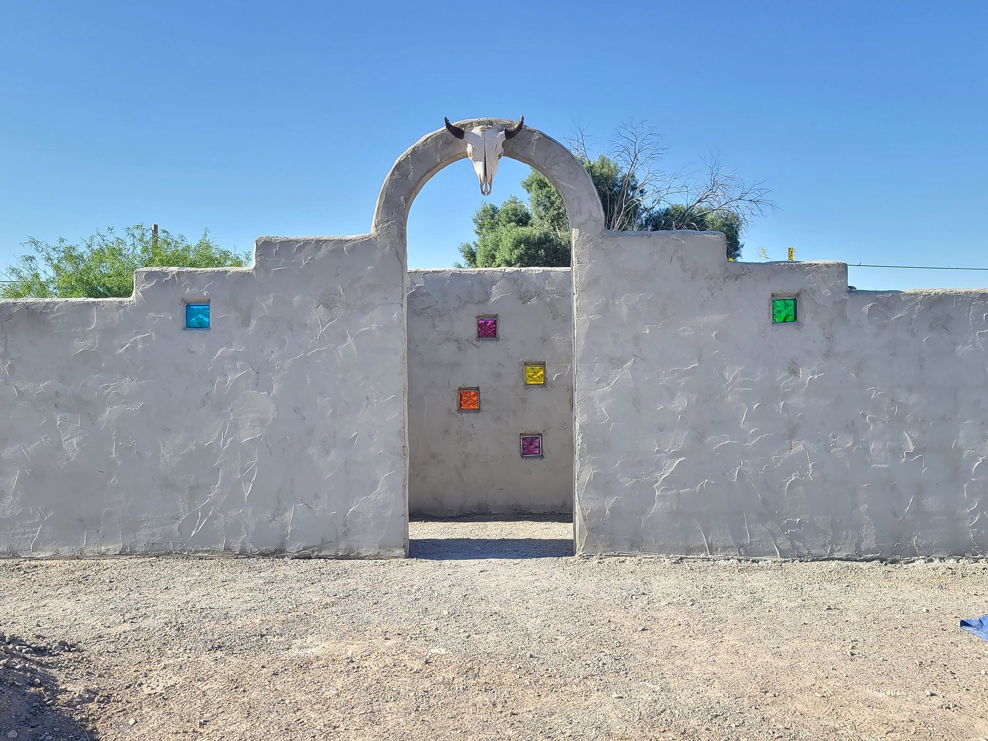The arched gate of Las Sombras, with coloured glass blocks set in the plaster